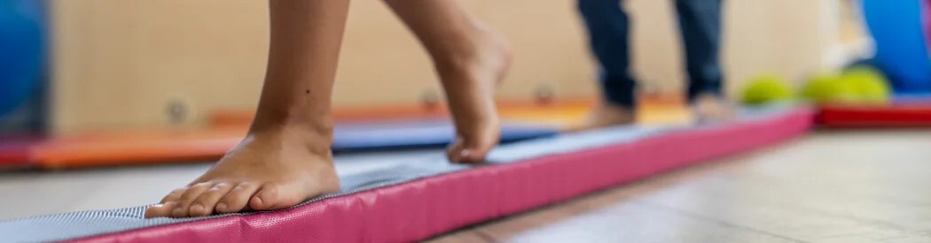 child walking across soft balance beam