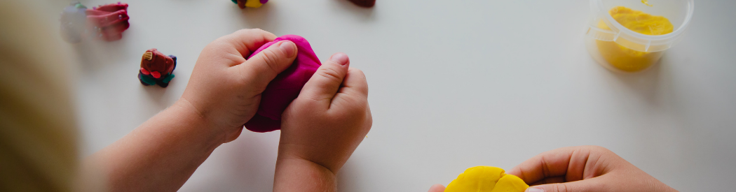 child playing with purple play dough