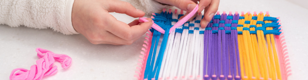 two hands weaving pipe cleaners in a lattice effect