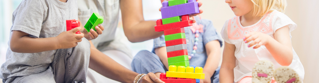 children playing with multicoloured plastic blocks
