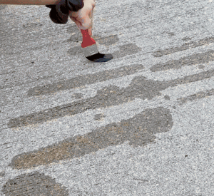 water mark‑making on ground with paintbrush style tools in sunshine