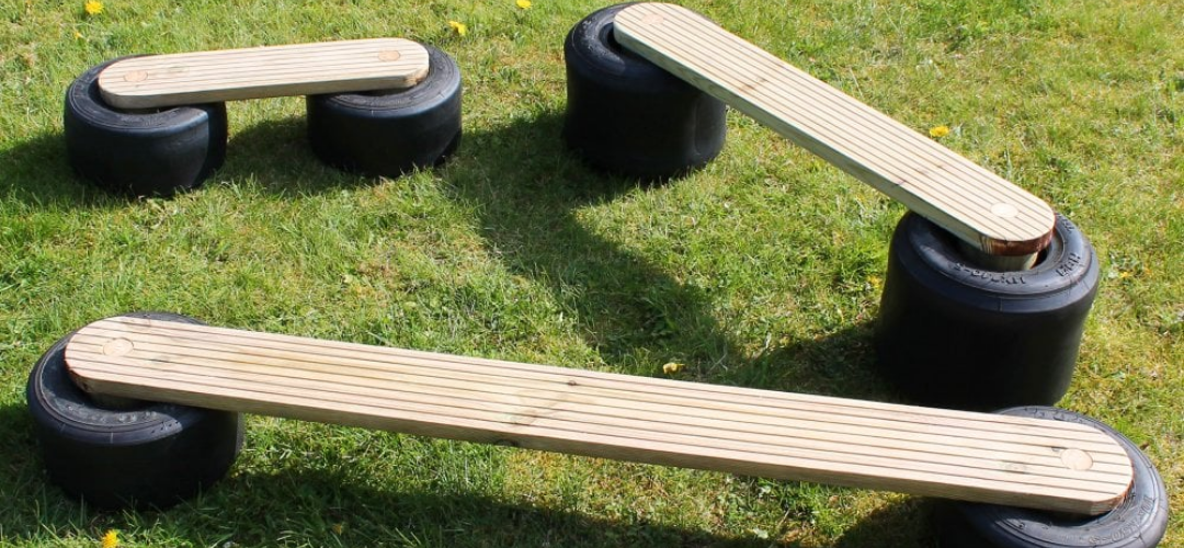 6 small tyres with wooden planks slotted into the holes of the tyres to create balance beams