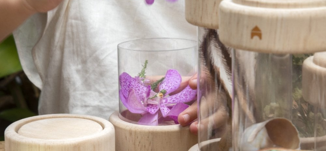 child storing flowers in treasure tubes