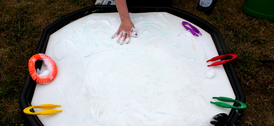 a hand pressing down on a sponge mat to create foam