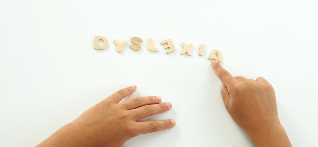 child spelling out dyslexia with wooden letters