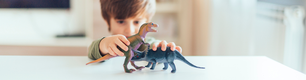 child role playing with toy dinosaurs