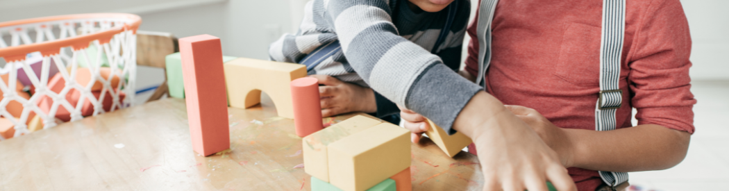 child playing with wooden construction blocks