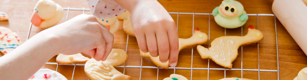 children putting on sprinkles on cookies
