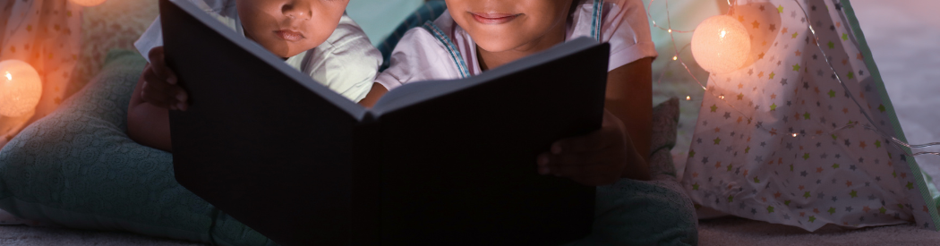 two children reading a story in den