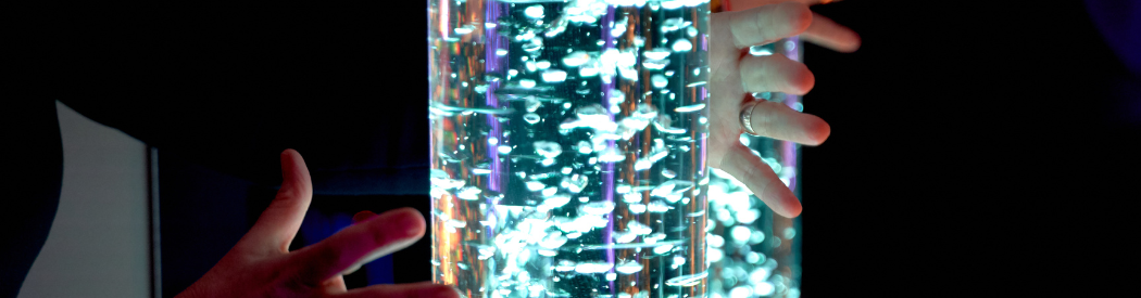 children reaching out for a light up sensory tube