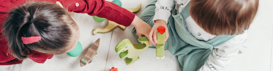 children playing with wooden dinosaur figures