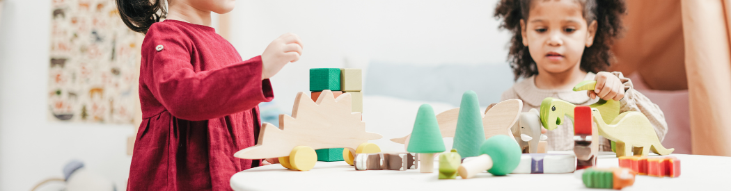 children playing with wooden blocks and dinosaur figures