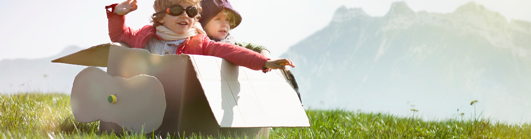 children airplane role play in cardboard box