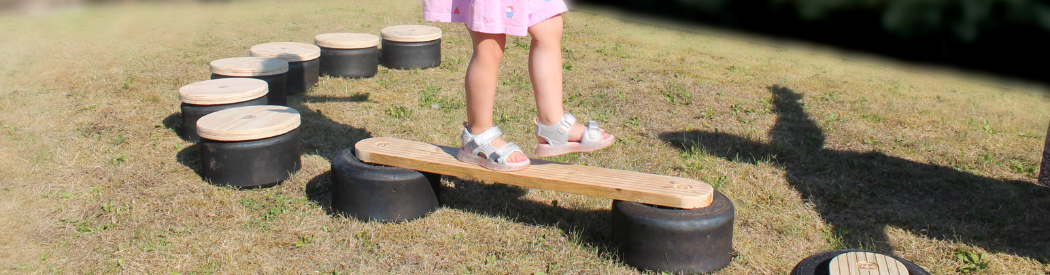 child balancing on wooden balance beam