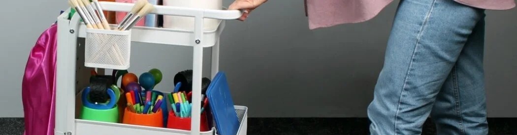 woman pushing a trolley filled with art essentials