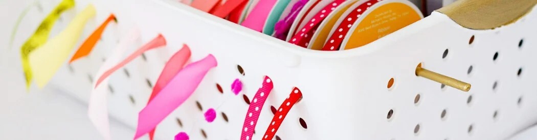ribbon stored in a basket and being fed through the holes of the basket