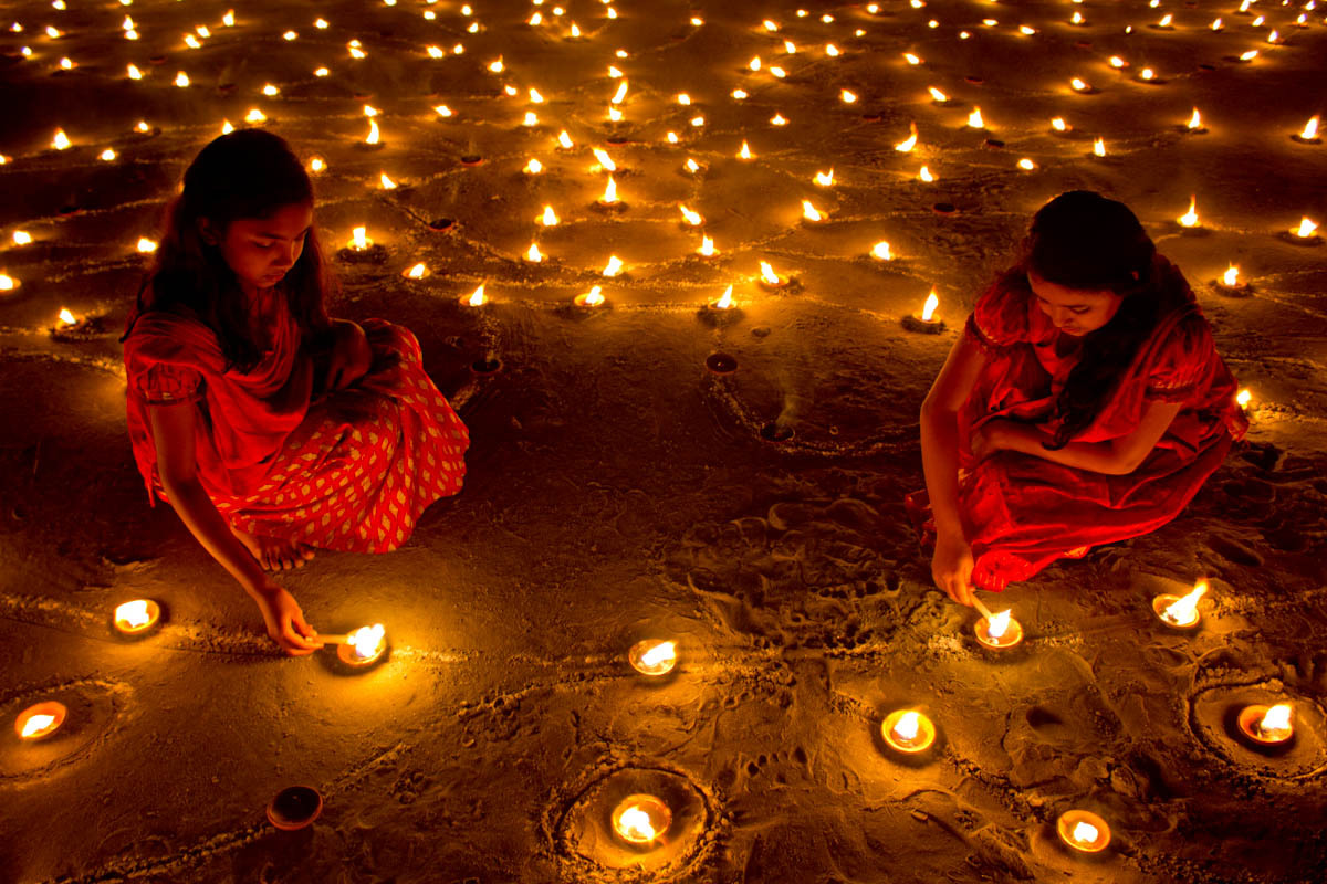 children lighting up candles during diwali