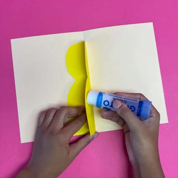 Person applying glue to yellow card