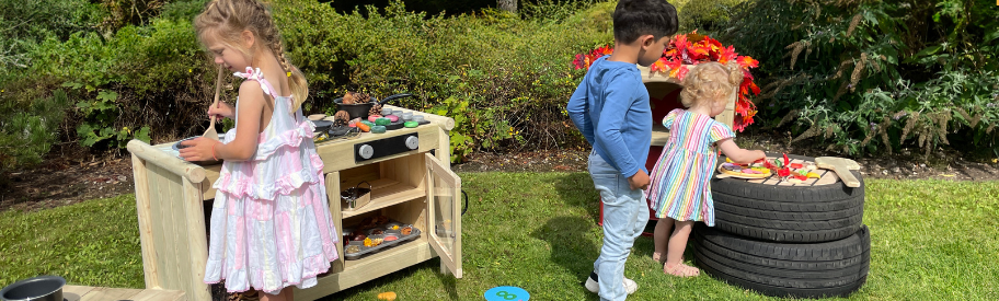 child playing with outdoor mud kitchen equipment