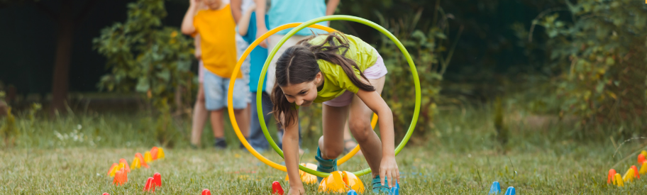 Primary school children taking part in an outdoor PE activity using sports equipment