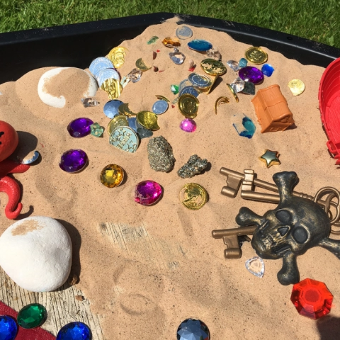 tuff tray filled with sand and random treasures