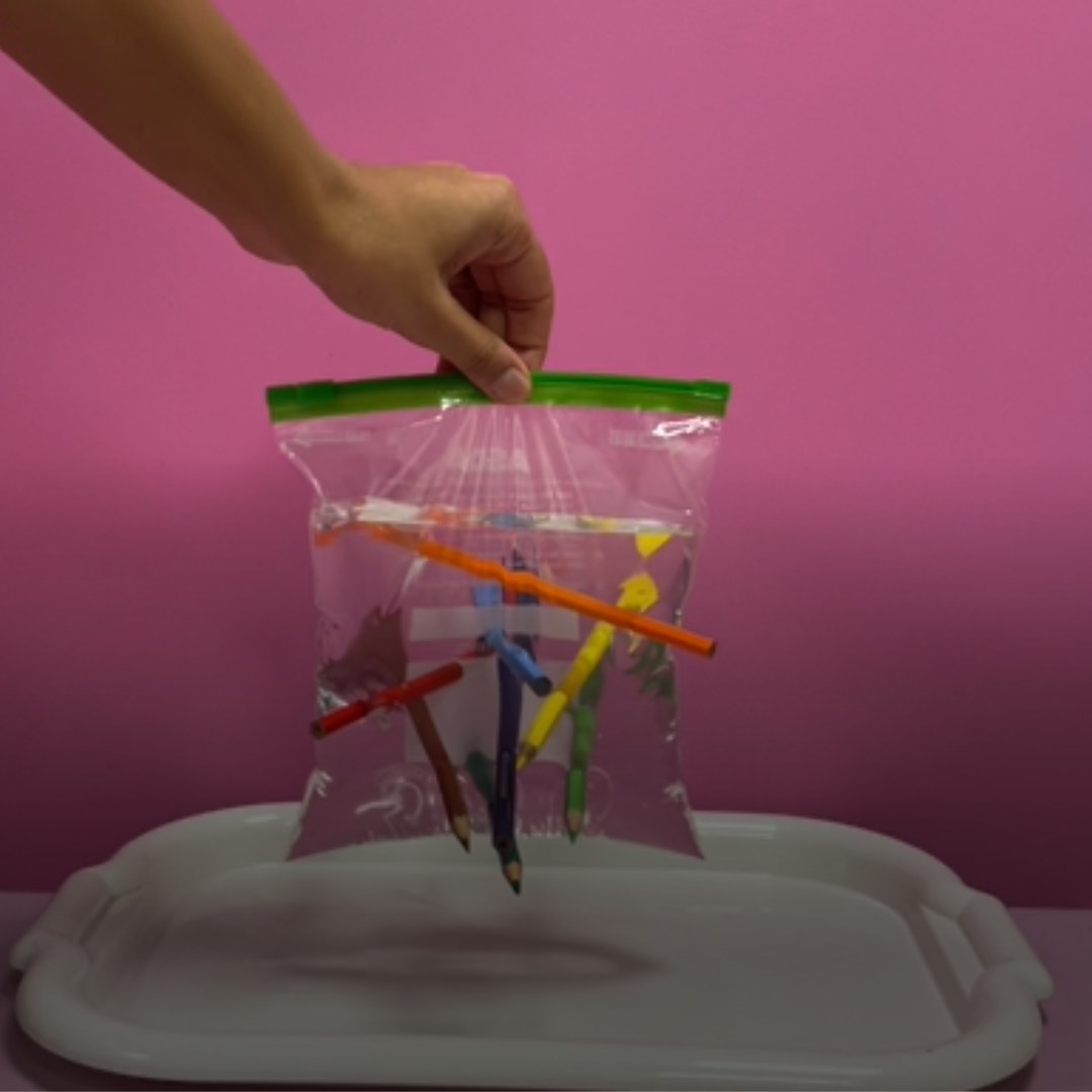 plastic bag filled with water with coloured pencils stuck in