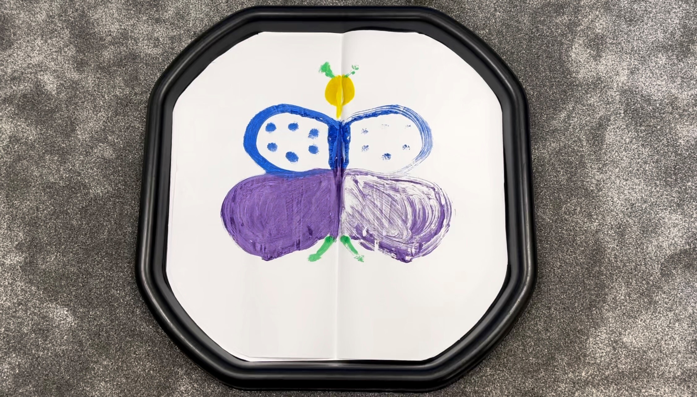 symmetrical butterfly painting on tuff tray paper pad